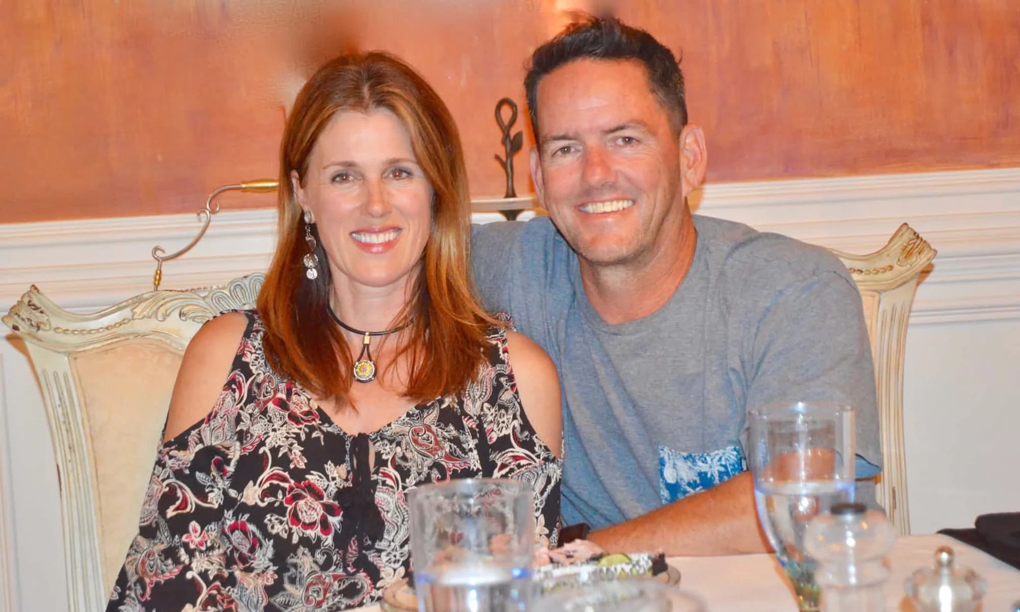 A couple smiling together at a dinner table