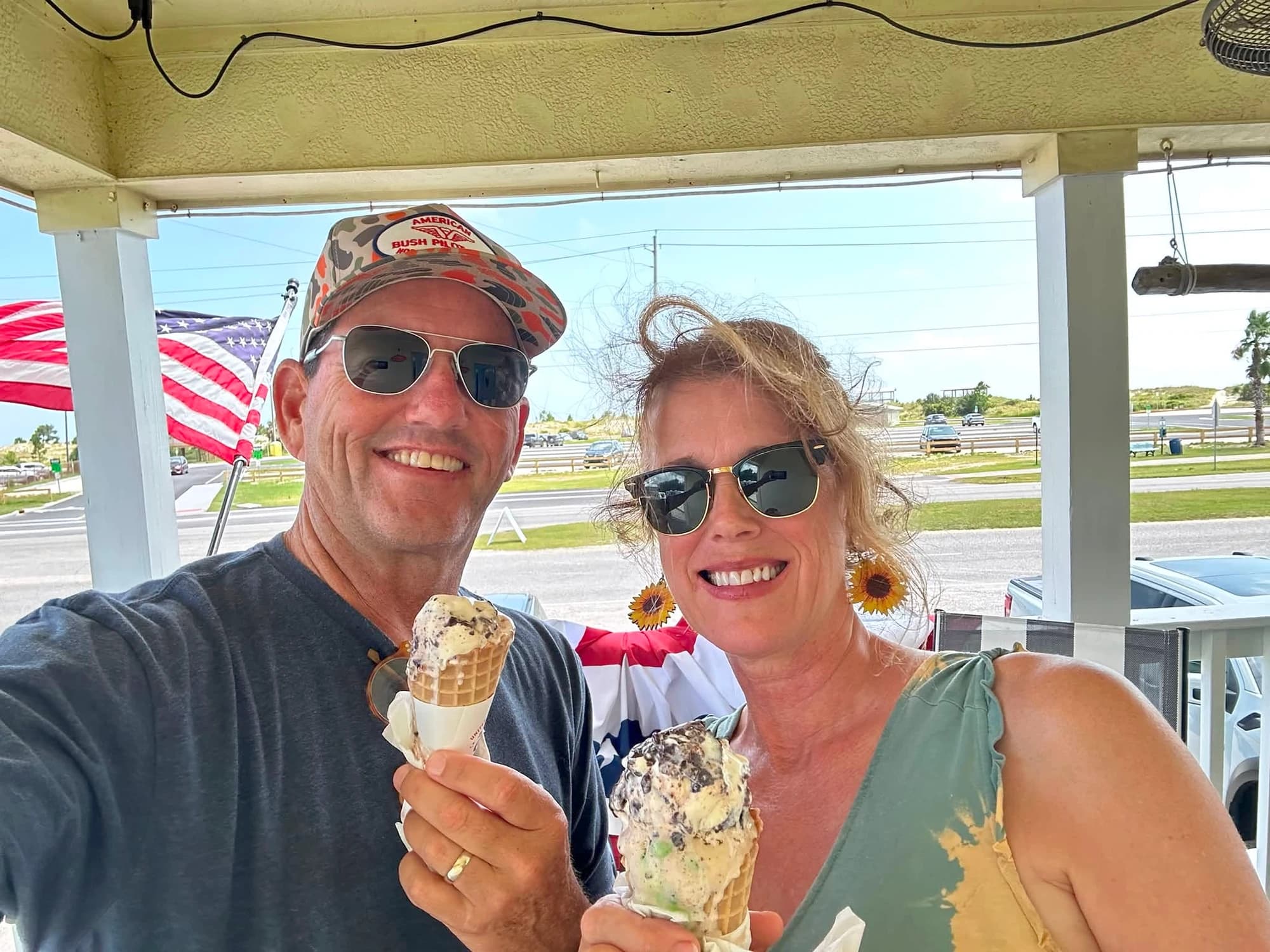 A couple holding ice cream cones on a sunny day