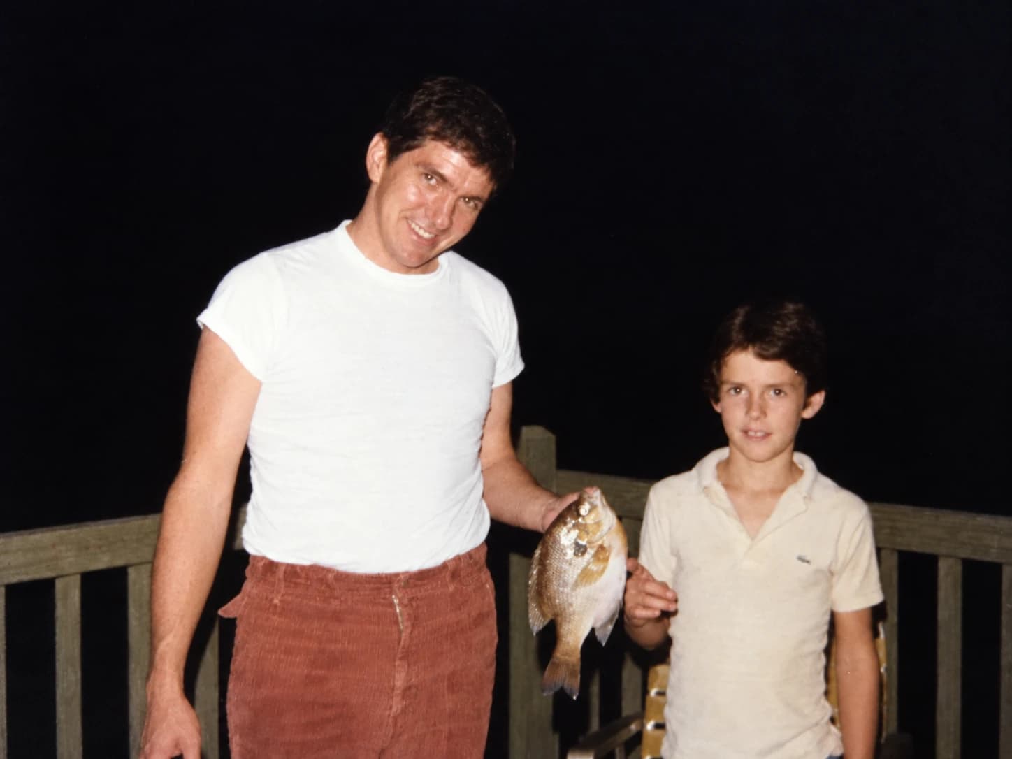 John Mann Sr., years ago, holding up a fish beside a young boy