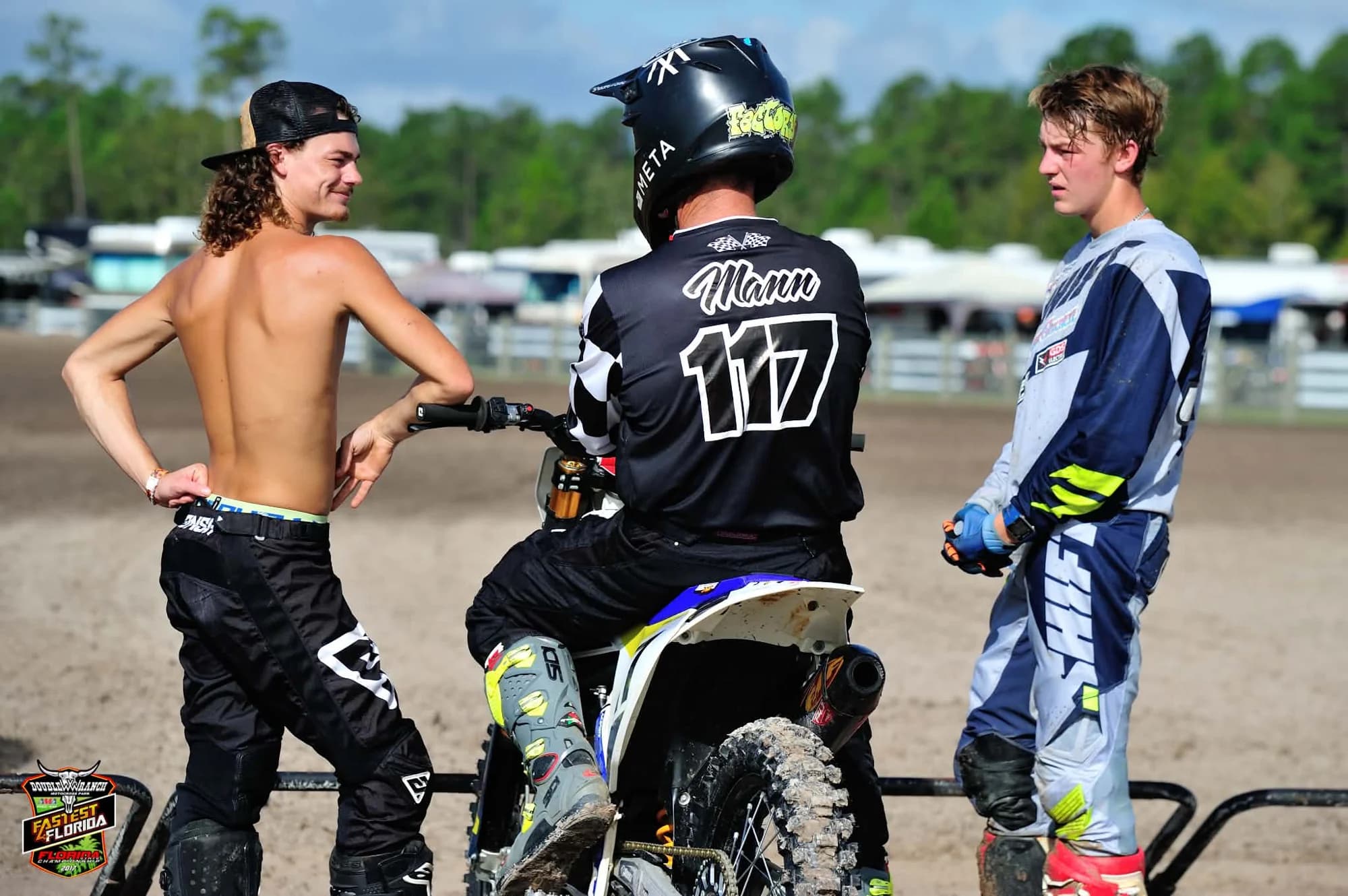 Frank in his Mann 117 jersey talking with two young riders at the track